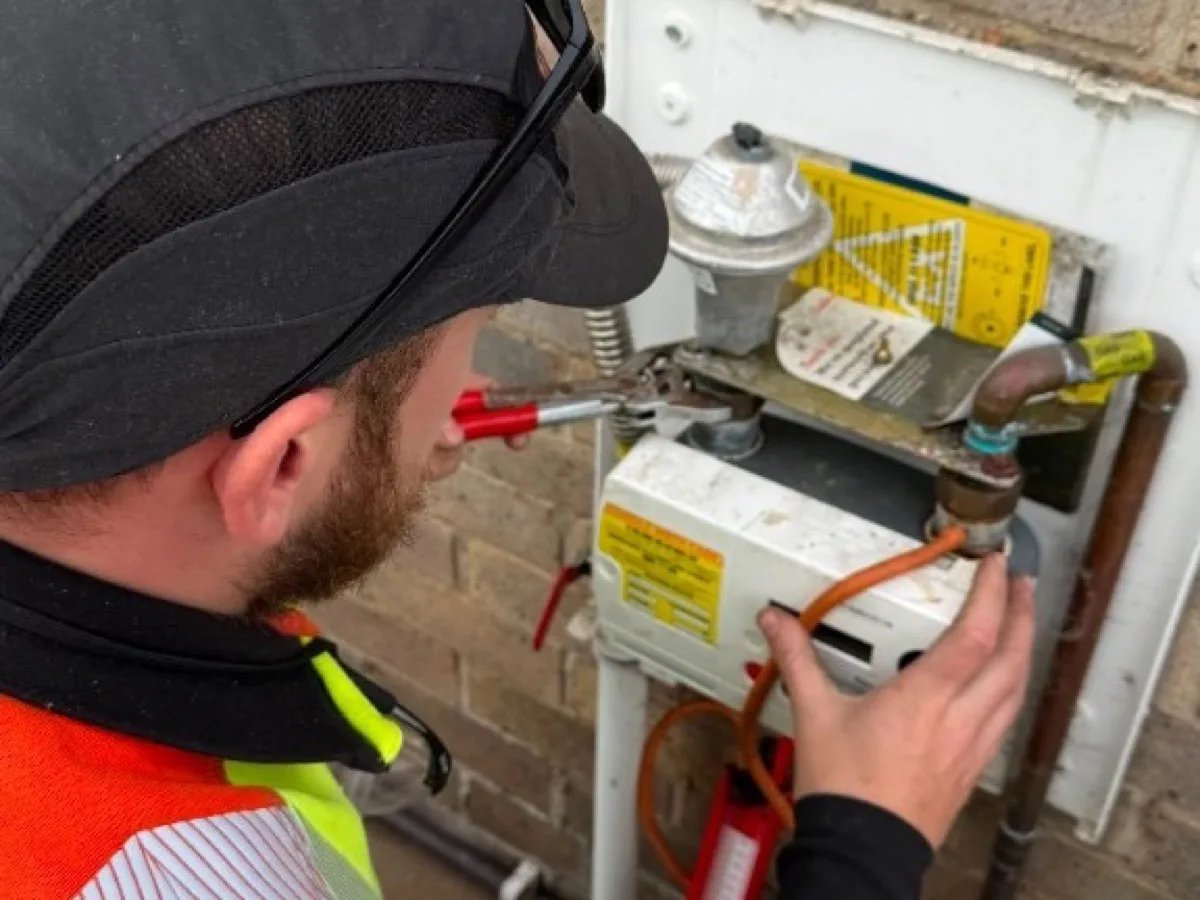 Gas Safe engineer pressure-testing a residential gas meter with a manometer